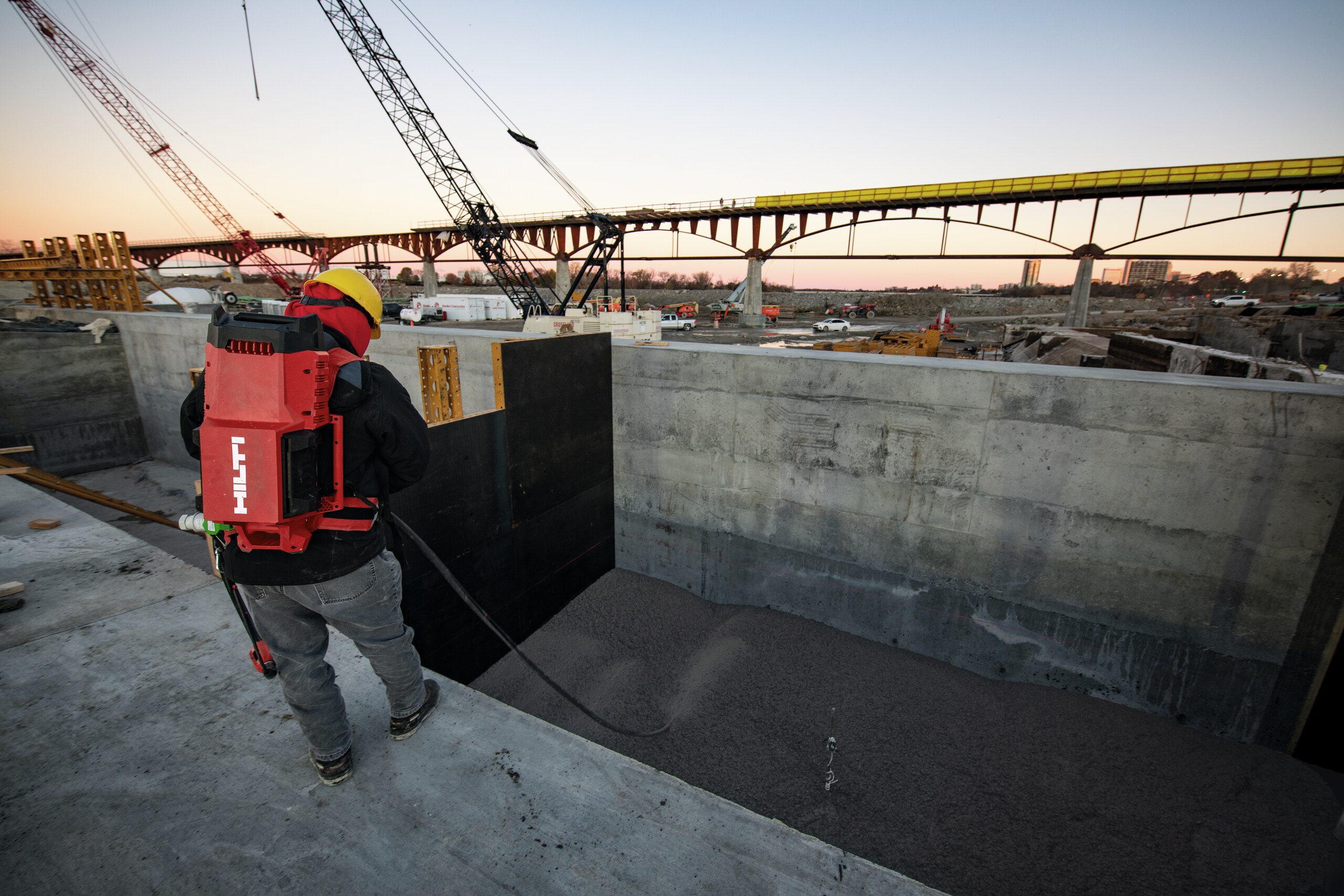 Un angajat vibrează betonul pe un șantier cu vibratorul de beton NCV 10-22