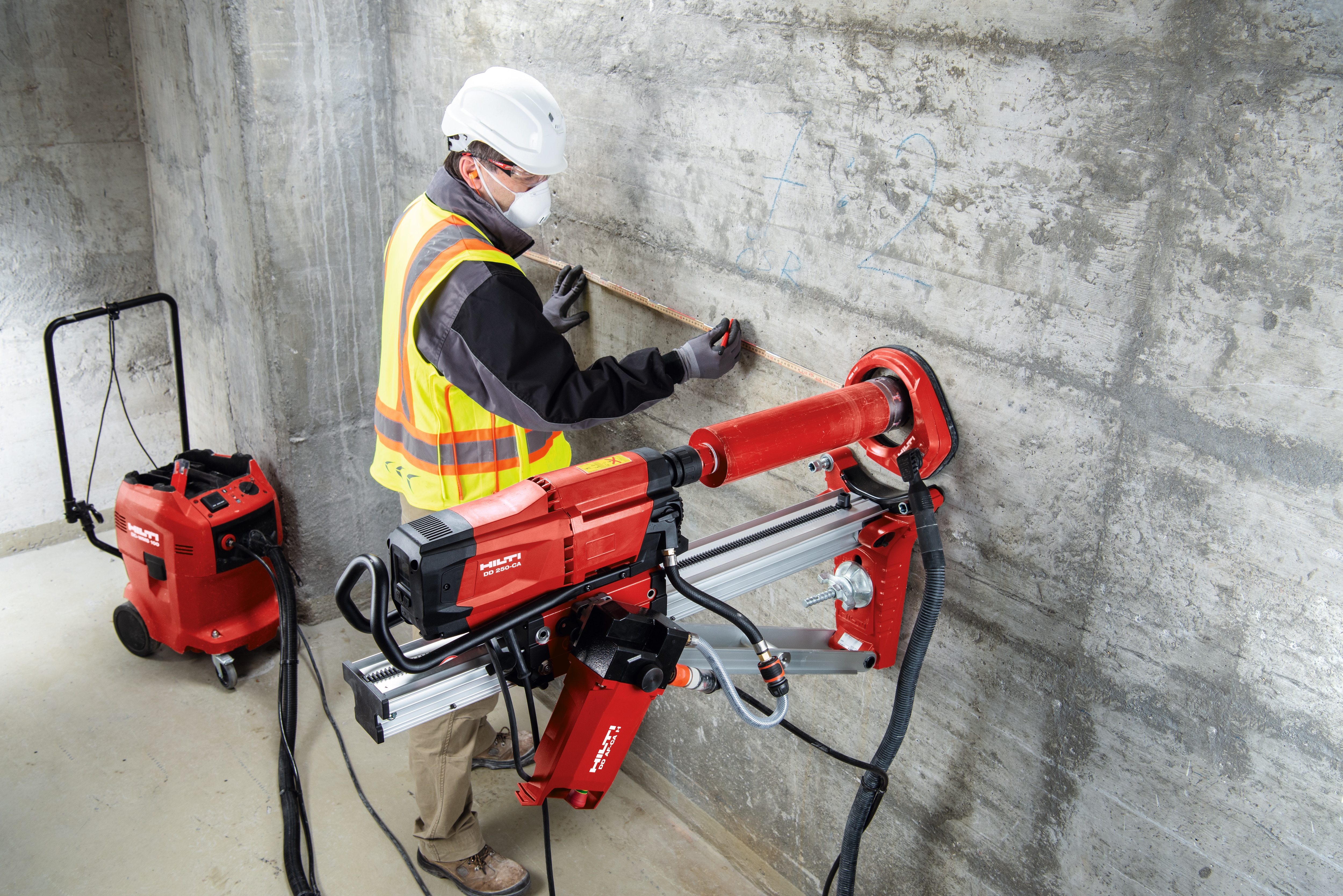 Operaio in cantiere mentre lavora con una carotatrice a diamante