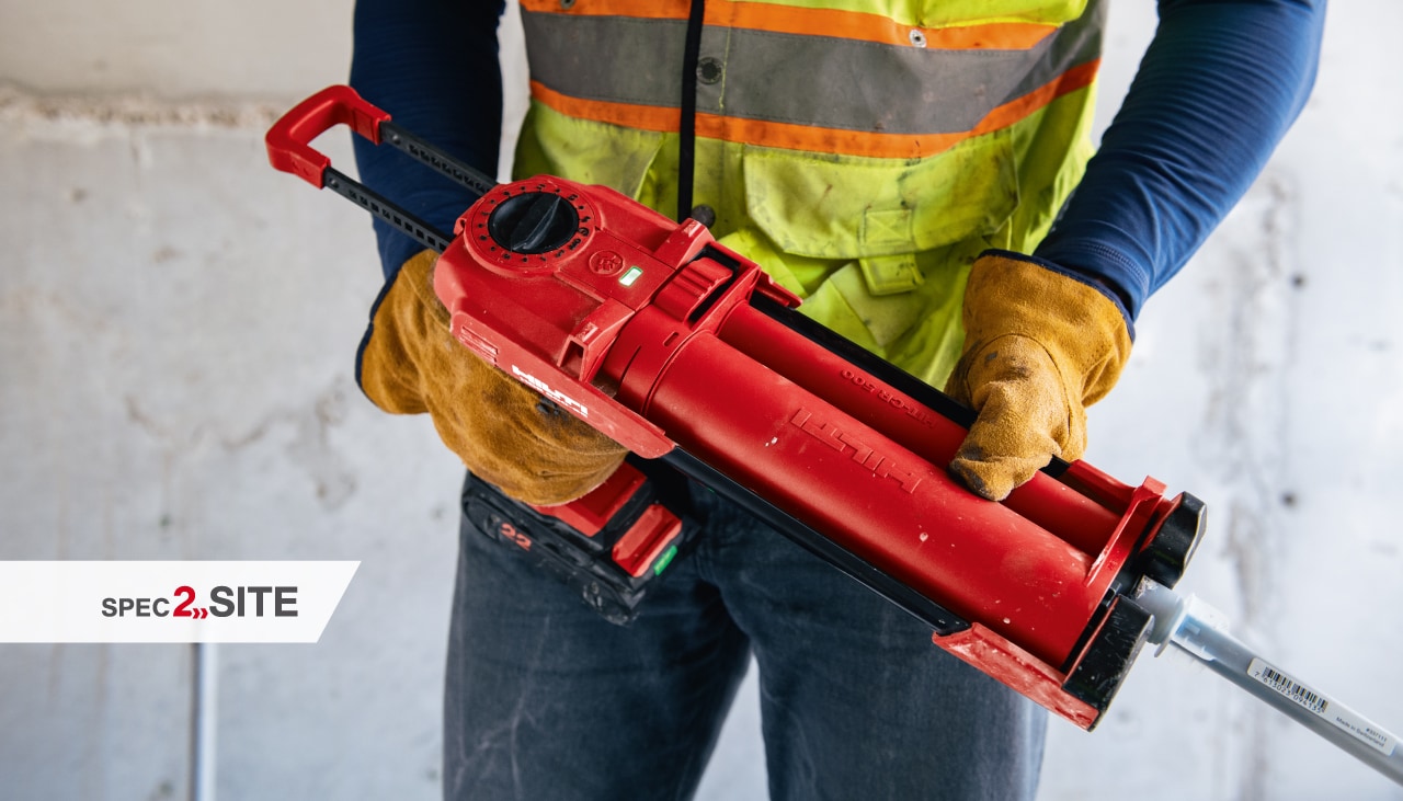 Un constructor instalează o ancoră în beton