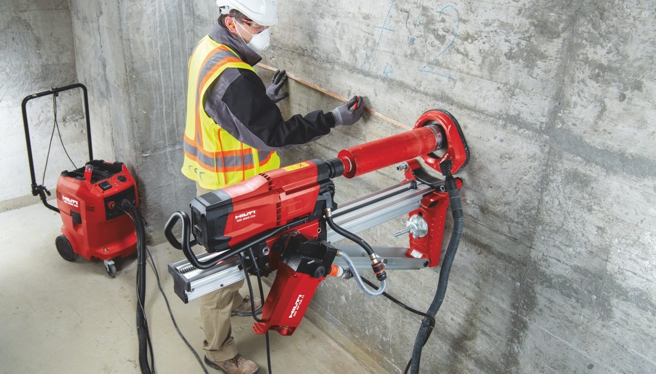 Operaio in cantiere mentre lavora con una carotatrice a diamante